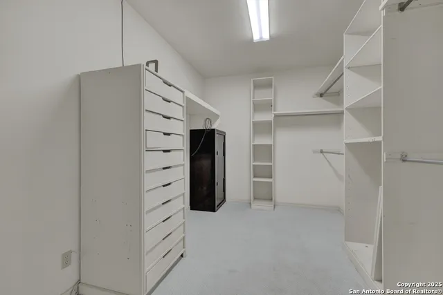 a view of walk in closet with empty racks