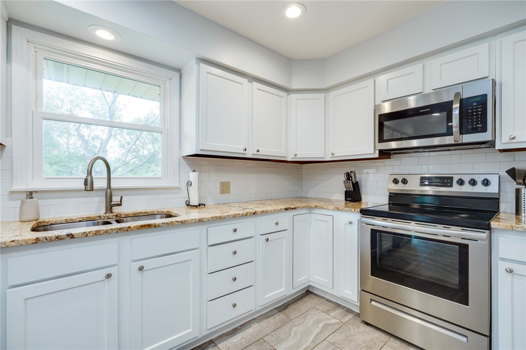 6950 Red Lion 5 Points Road Springboro, OH 45066 - Photo 21 of 78 This bright kitchen features ample cabinetry, granite counters, and modern appliances, perfect for daily living.