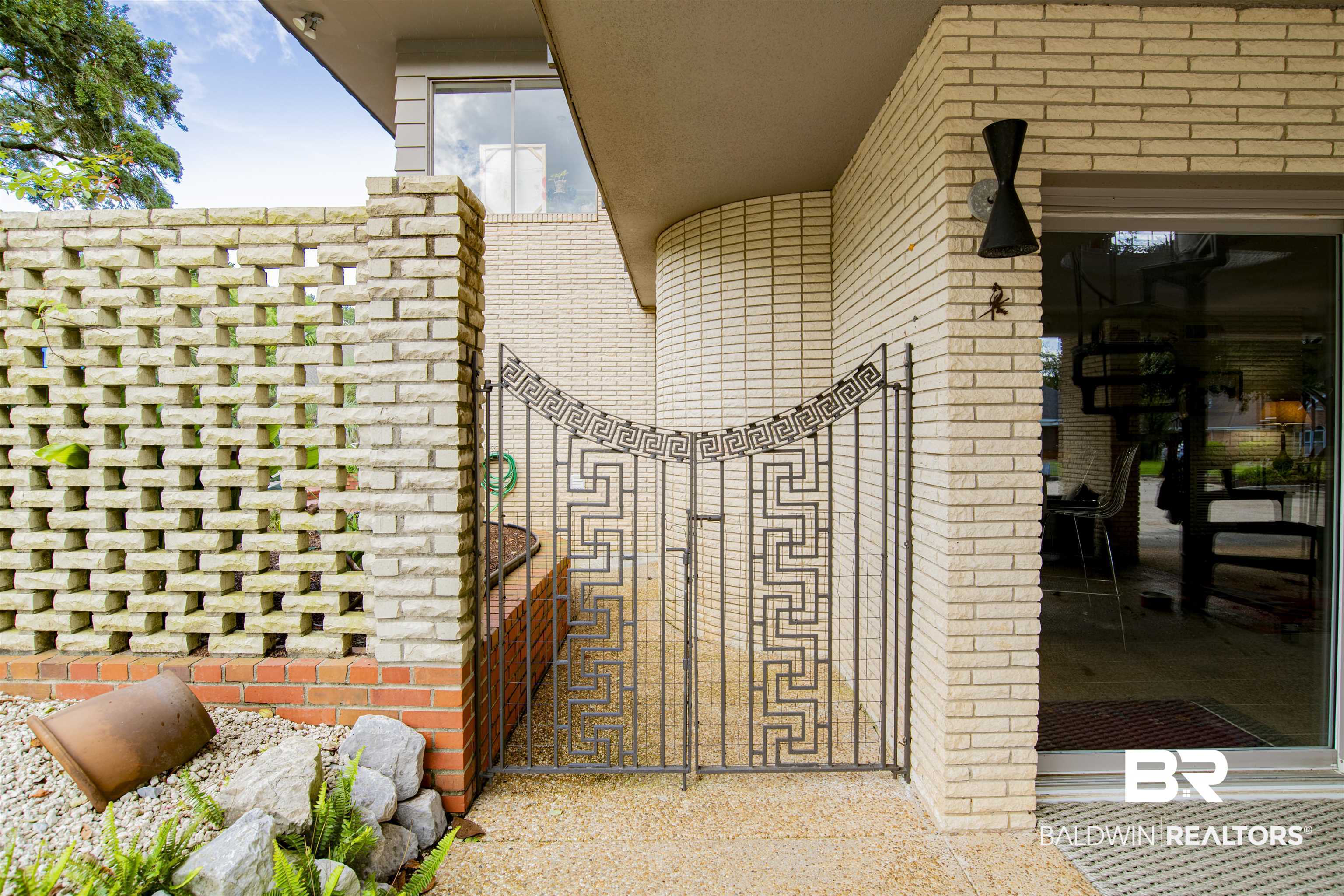 809 Bernard Circle Mobile, AL 36693 - Photo 52 of 75 Cream brick exterior with an ornate black wrought iron gate