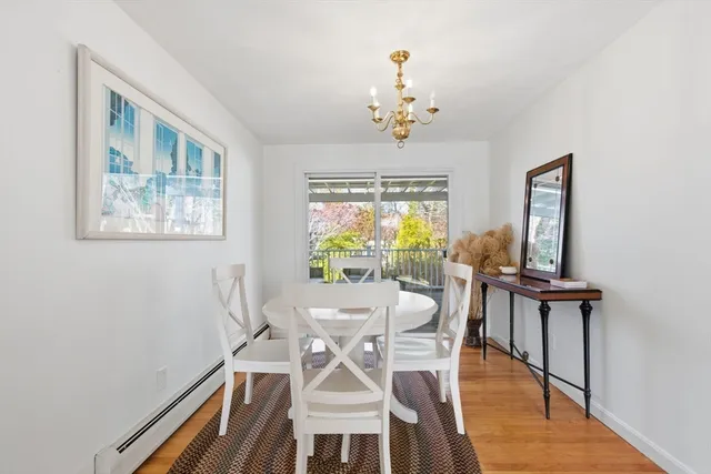 a view of a dining room with furniture a chandelier and wooden floor