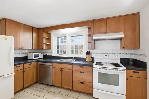a kitchen with a stove sink and cabinets