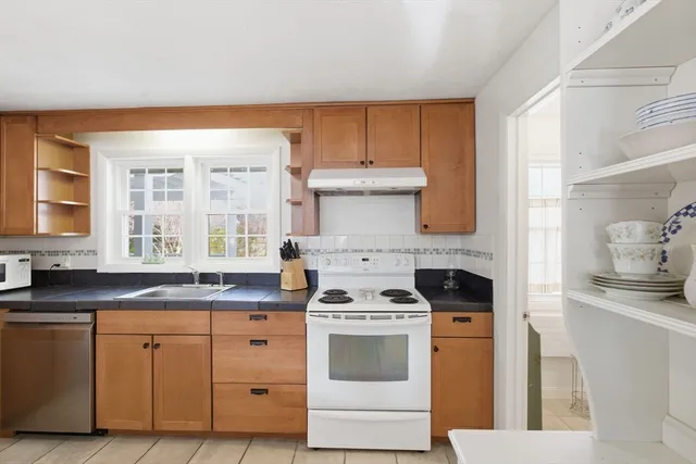 a kitchen with cabinets appliances a sink and a window