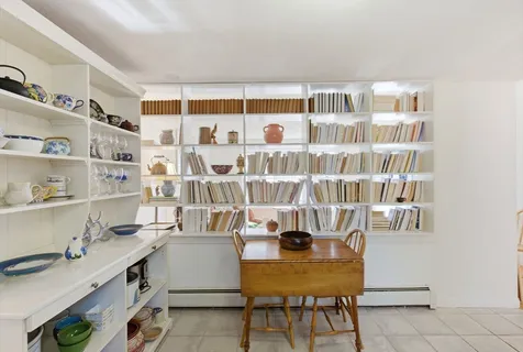 a room with a workspace and a bookshelf