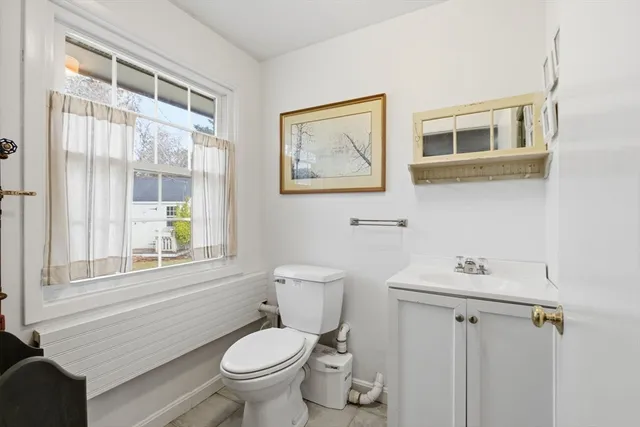 a bathroom with a sink a toilet and a window