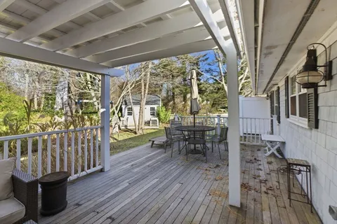 a view of a porch with furniture and wooden floor