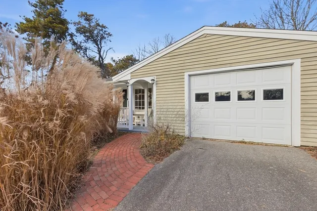 a view of a house with a small yard and garage