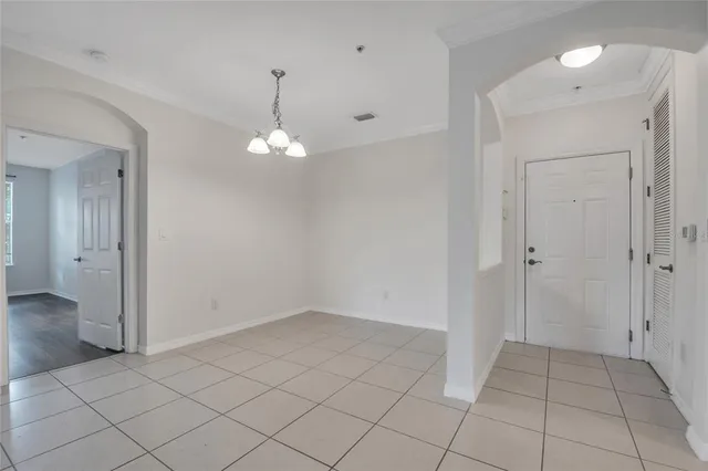 an empty room with chandelier and bathroom