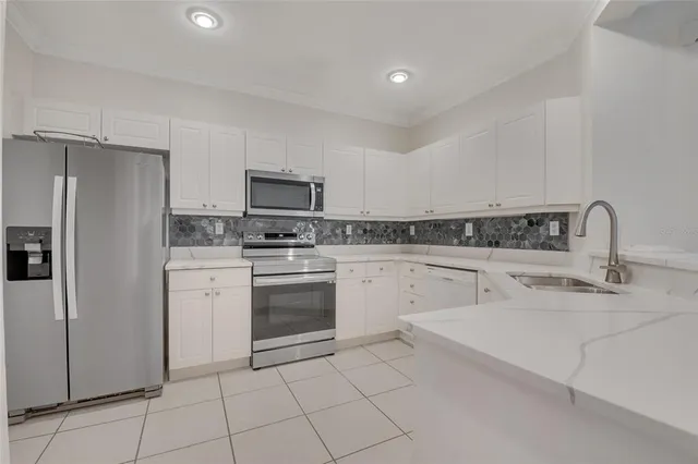 a kitchen with white cabinets a sink and white appliances