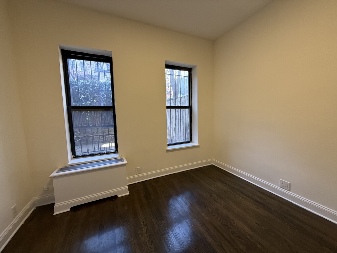 73 Thompson Street, Unit 1A Manhattan, NY 10012 - Photo 4 of 6 a view of an empty room with wooden floor and a window