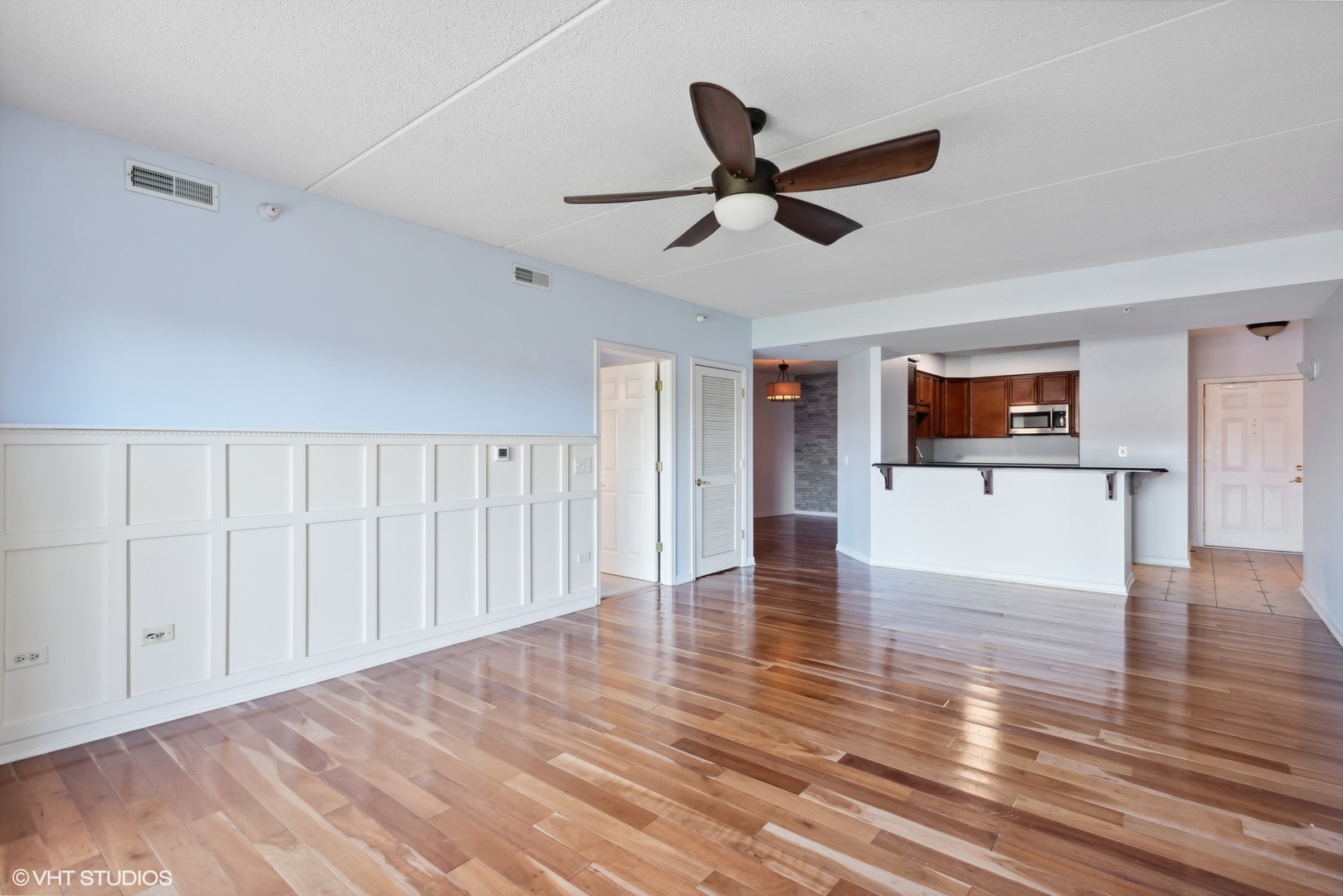 701 West Rand Road, Unit 330 Arlington Heights, IL 60004 - Photo 2 of 16 a view of a livingroom with wooden floor and a ceiling fan