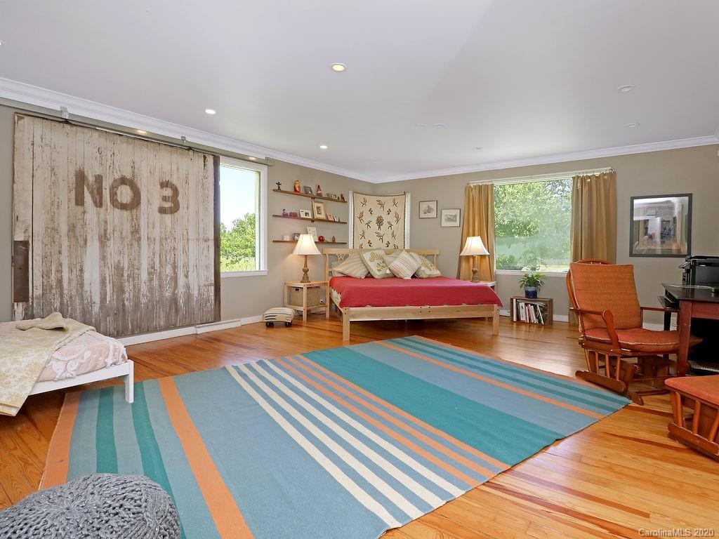 315 Shoals Falls Road Hendersonville, NC 28739 - Photo 13 of 47 a bedroom with a bed and wooden floor