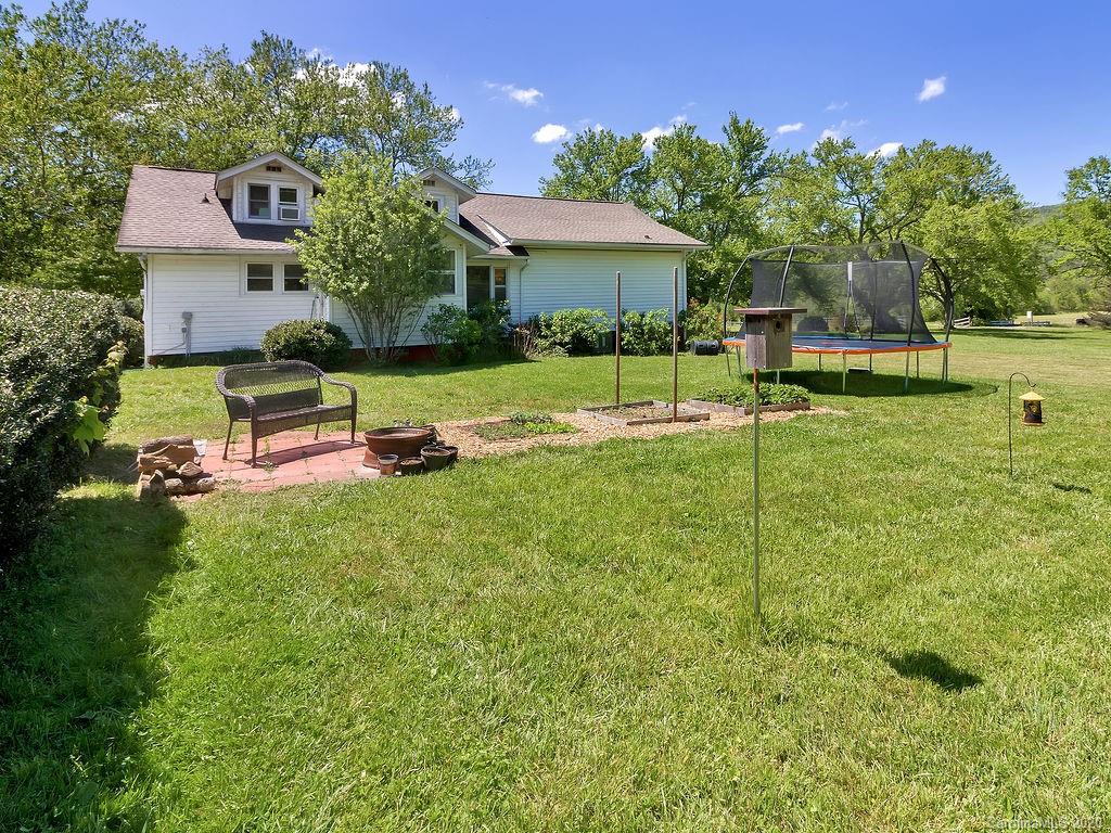 315 Shoals Falls Road Hendersonville, NC 28739 - Photo 18 of 47 a view of a house with a backyard porch and sitting area