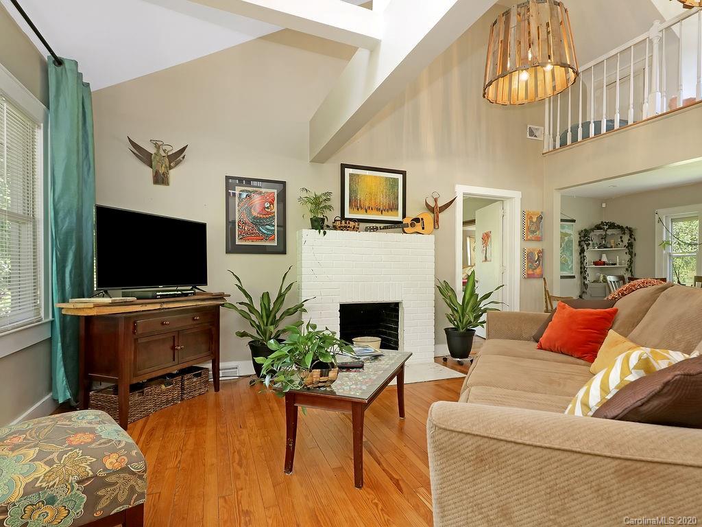 315 Shoals Falls Road Hendersonville, NC 28739 - Photo 6 of 47 a living room with furniture a flat screen tv and a fireplace
