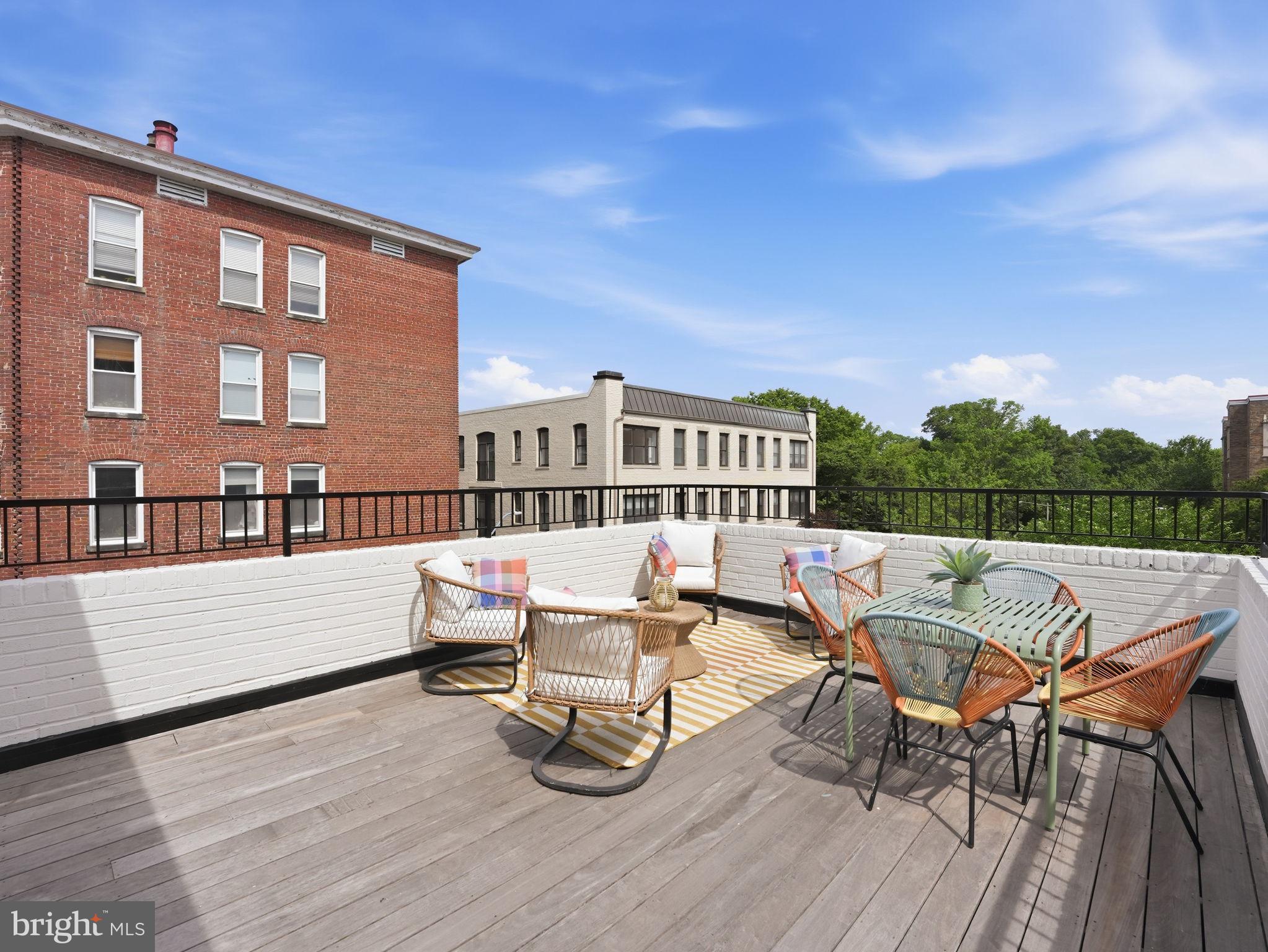 1845 Calvert Street Northwest Washington, DC 20009 - Photo 31 of 48 a roof deck with table and chairs and wooden floor