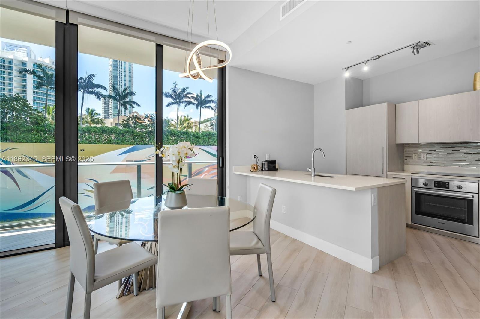 501 Northeast 31st Street, Unit 306 Miami, FL 33137 - Photo 11 of 65 a kitchen with a table chairs stove and cabinets