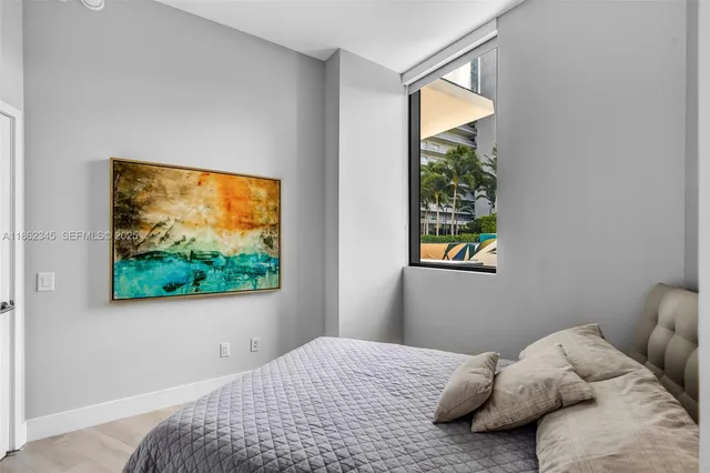 a bedroom with a bed and a painting on the wall