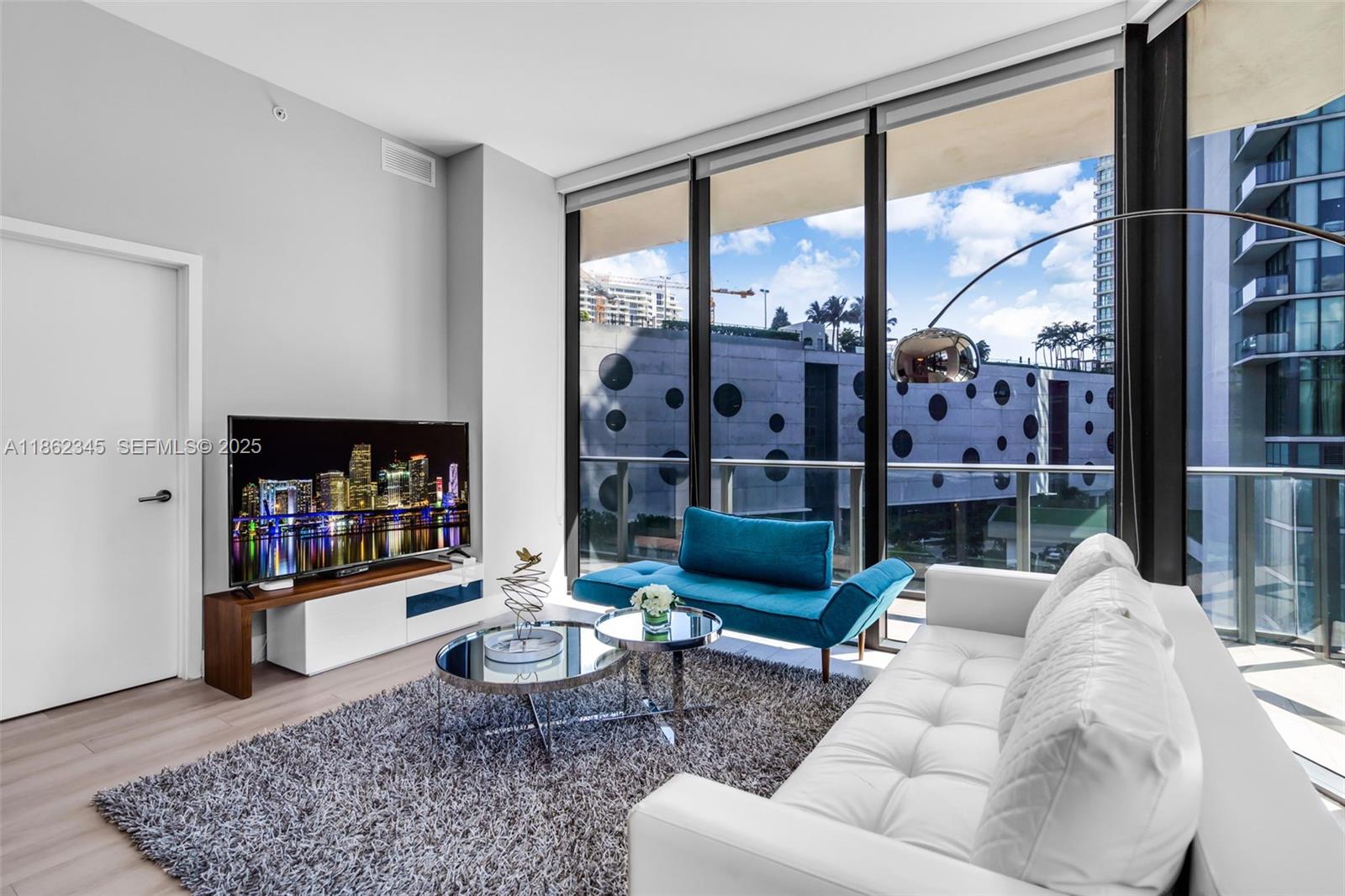 501 Northeast 31st Street, Unit 306 Miami, FL 33137 - Photo 2 of 65 a living room with furniture and a floor to ceiling window