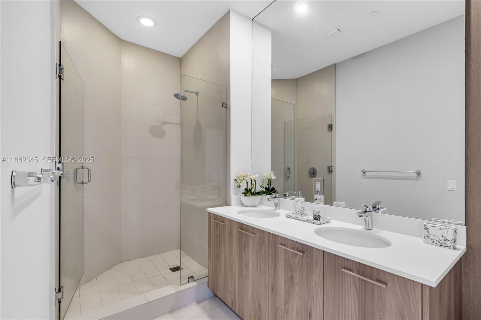 501 Northeast 31st Street, Unit 306 Miami, FL 33137 - Photo 23 of 65 a bathroom with a double vanity sink mirror and shower