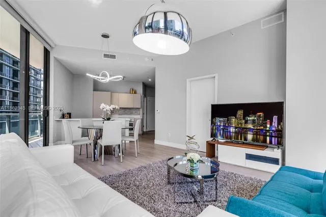 a dining room with furniture a chandelier and glass door