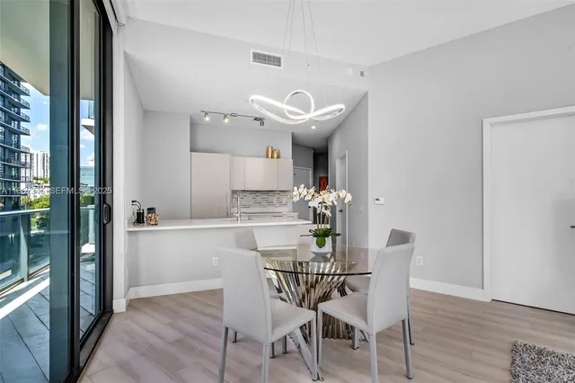 a dining room with furniture a chandelier and window