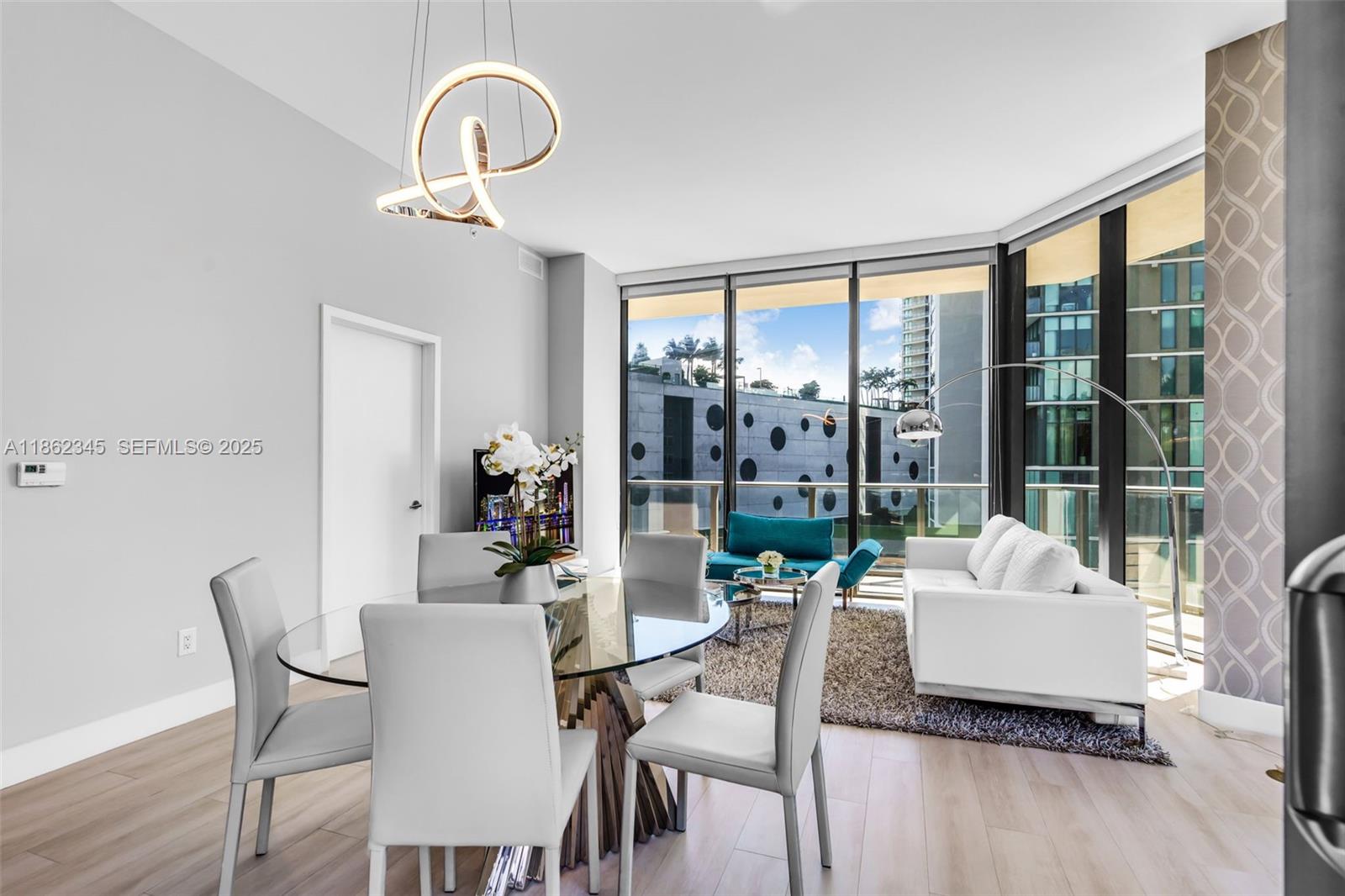 501 Northeast 31st Street, Unit 306 Miami, FL 33137 - Photo 10 of 65 a dining room with furniture a chandelier and window