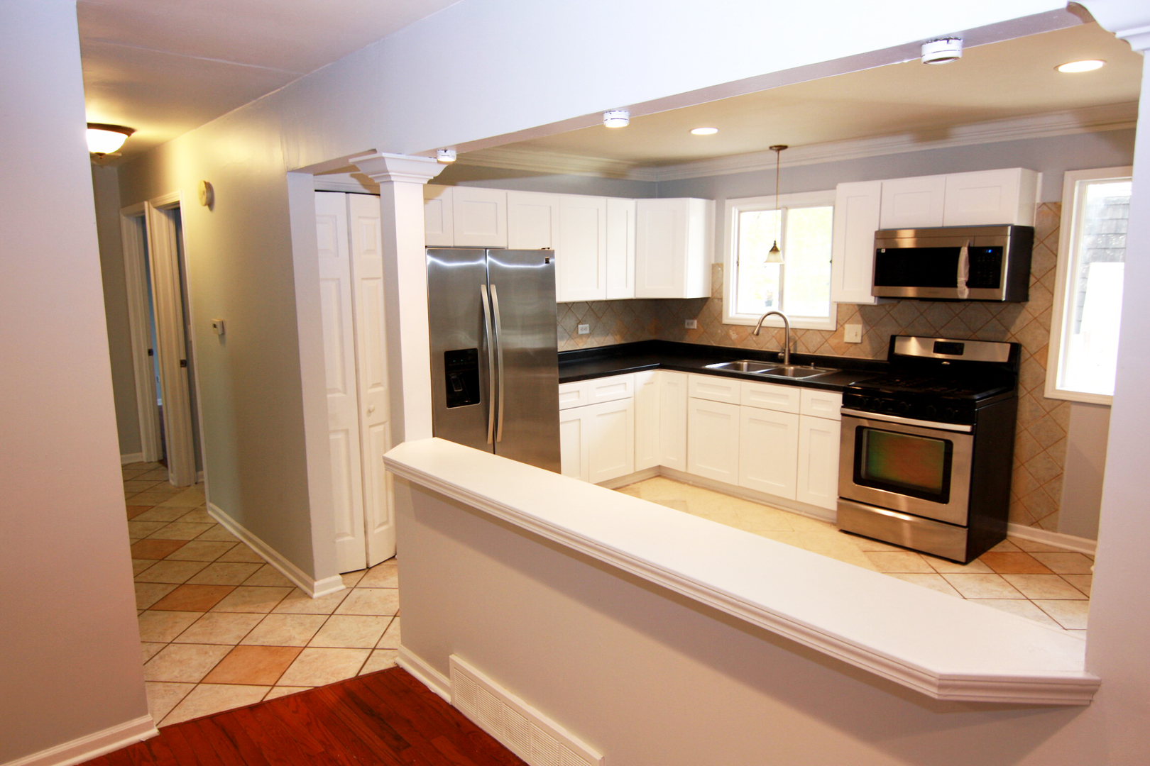 115 Kings Road Carpentersville, IL 60110 - Photo 5 of 16 a kitchen with stainless steel appliances a refrigerator a sink a stove top oven a counter space and cabinets