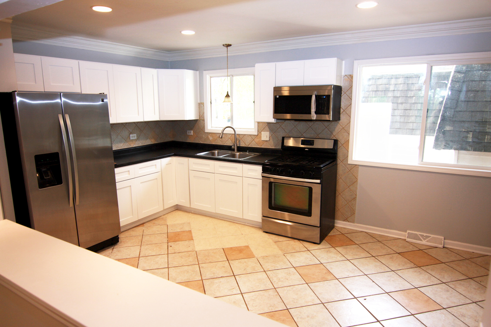 115 Kings Road Carpentersville, IL 60110 - Photo 6 of 16 a kitchen with stainless steel appliances granite countertop a stove a sink and a microwave