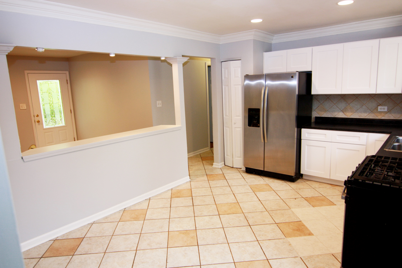 115 Kings Road Carpentersville, IL 60110 - Photo 7 of 16 a view of a refrigerator in kitchen and an empty room in wooden floor