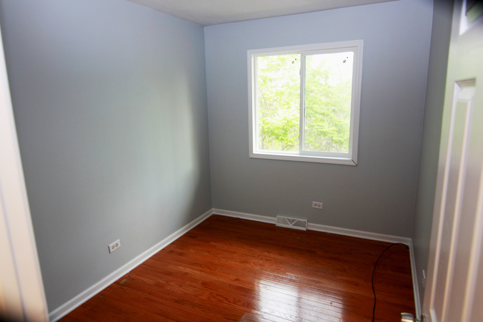115 Kings Road Carpentersville, IL 60110 - Photo 10 of 16 an empty room with wooden floor and a window