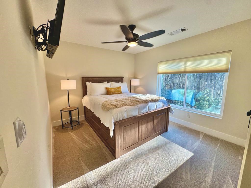 939 Sunset Road Epworth, GA 30541 - Photo 17 of 30 a bedroom with a bed and a chandelier
