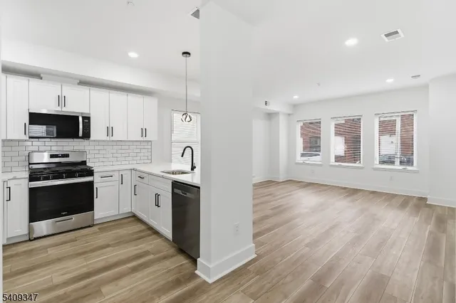 a kitchen with stove cabinets and wooden floor