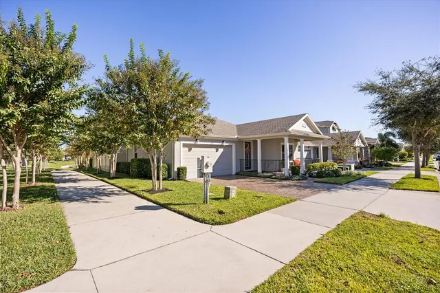 a front view of a house with a yard and potted plants