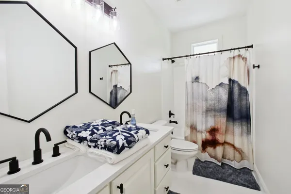 a bathroom with a sink a toilet and a mirror
