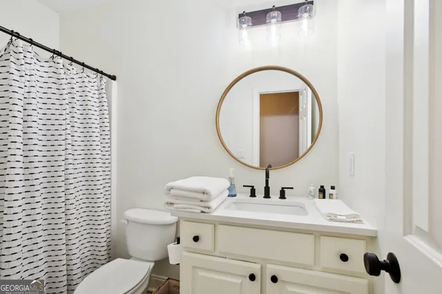a bathroom with a sink a toilet and a mirror