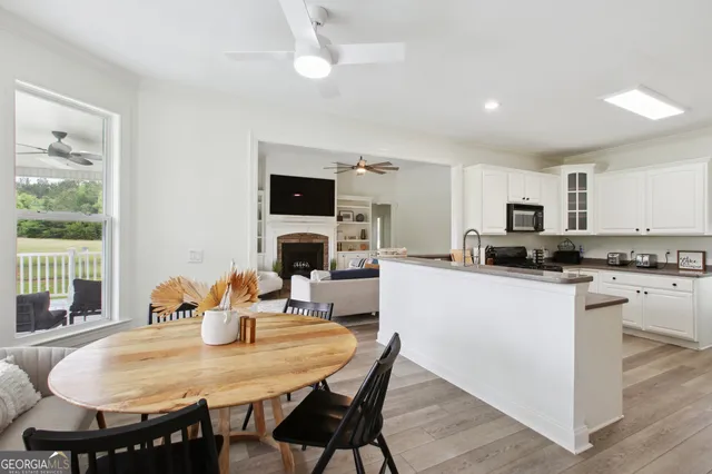 a kitchen with stainless steel appliances granite countertop a dining table and chairs