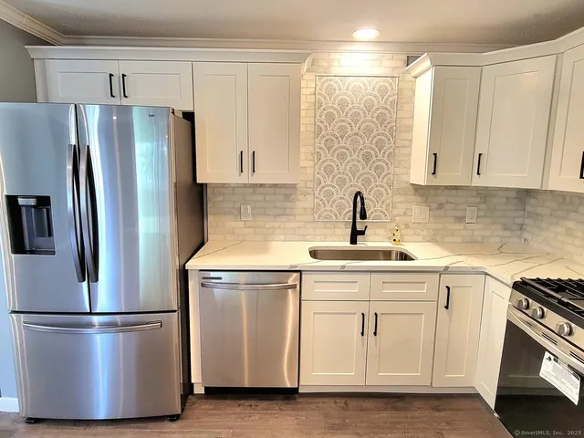 a kitchen with a refrigerator sink and cabinets