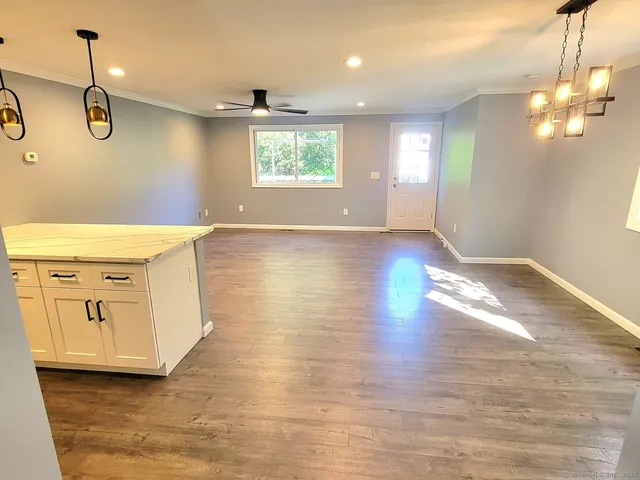a view of a kitchen with wooden floor and windows