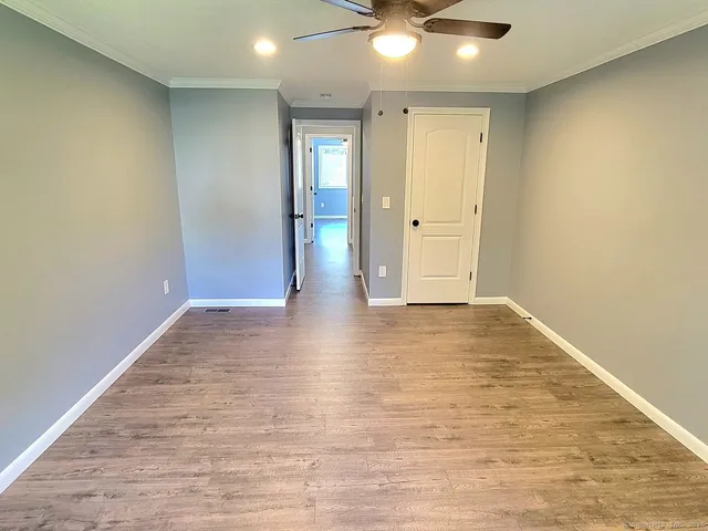 an empty room with wooden floor and door