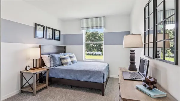 a bedroom with a bed a lamp and a window