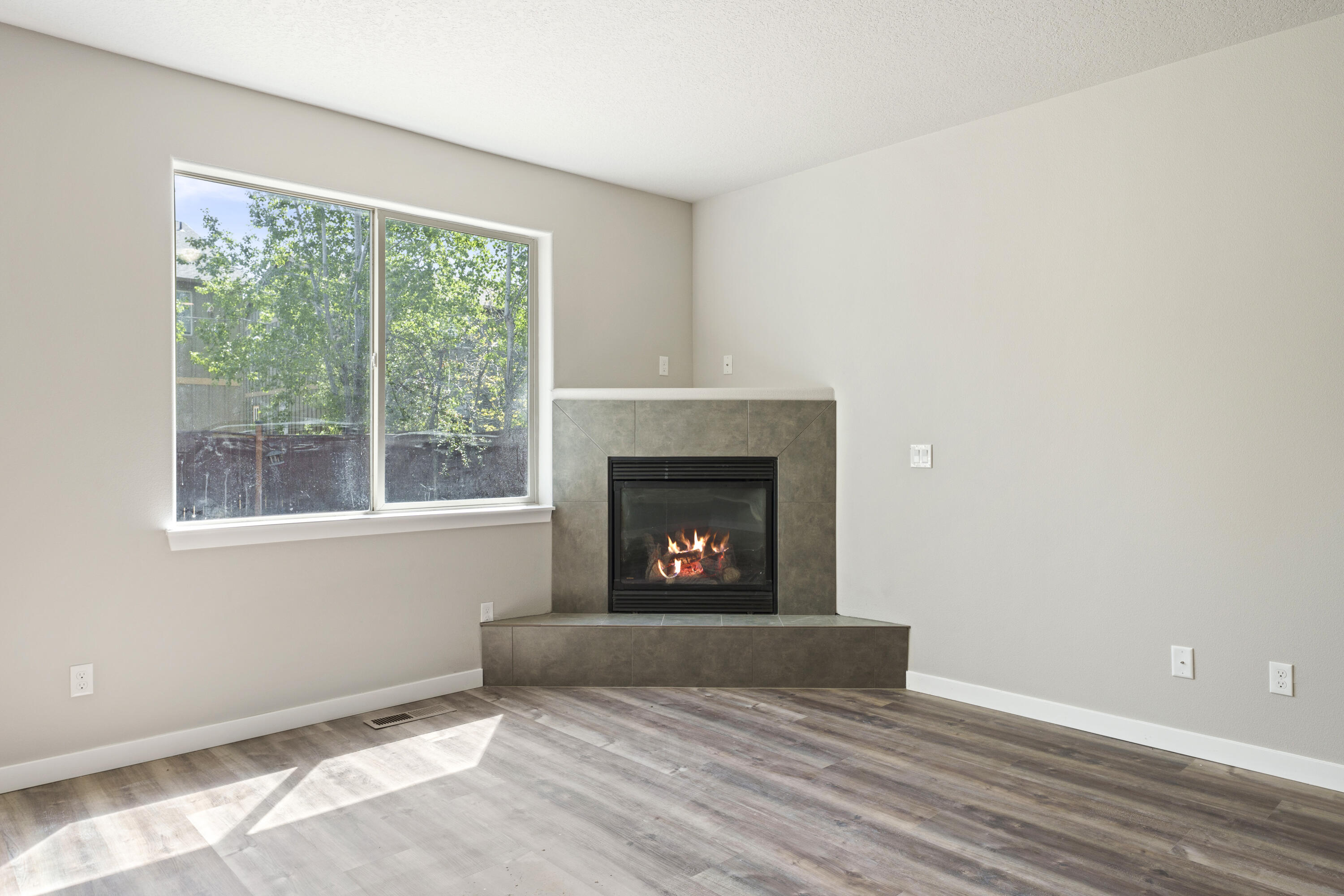 21189 Ritz Place Bend, OR 97702 - Photo 8 of 37 a view of an empty room with wooden floor fireplace and a window