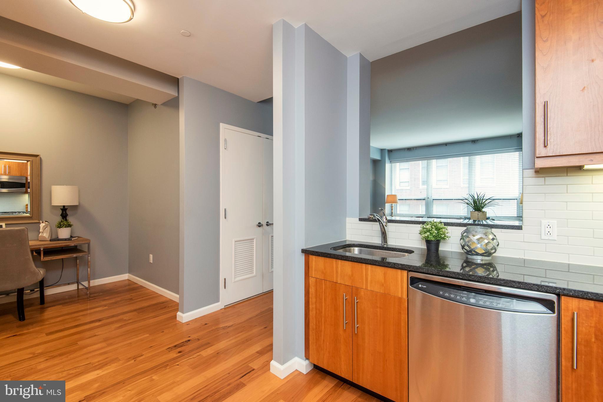1425 Locust Street, Unit 4F Philadelphia, PA 19102 - Photo 15 of 34 a kitchen with stainless steel appliances granite countertop wooden floors and sink