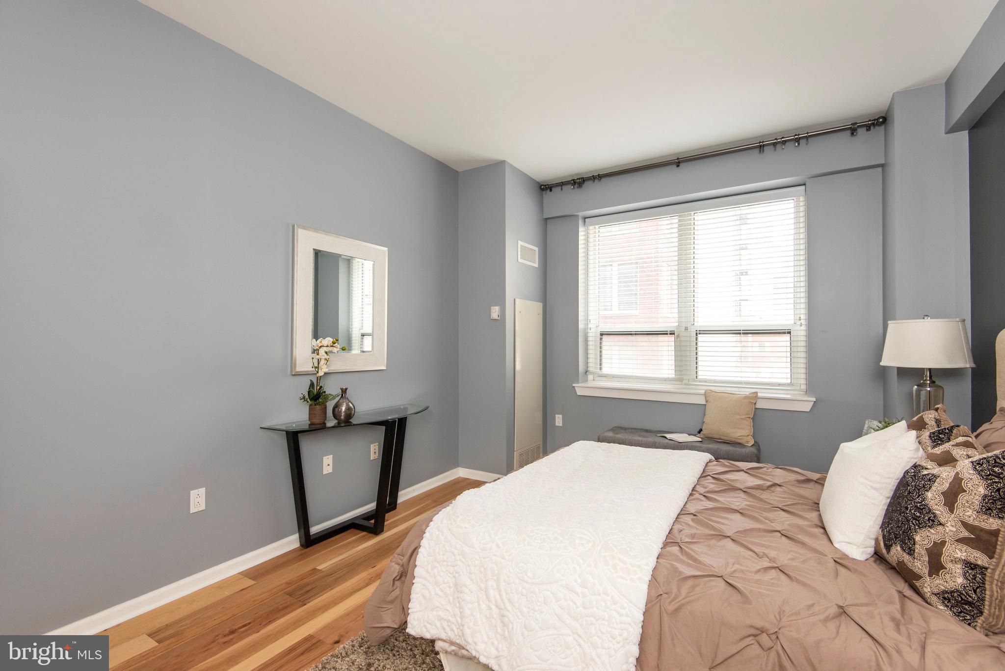 1425 Locust Street, Unit 4F Philadelphia, PA 19102 - Photo 18 of 34 a bedroom with a bed and a lamp on dresser