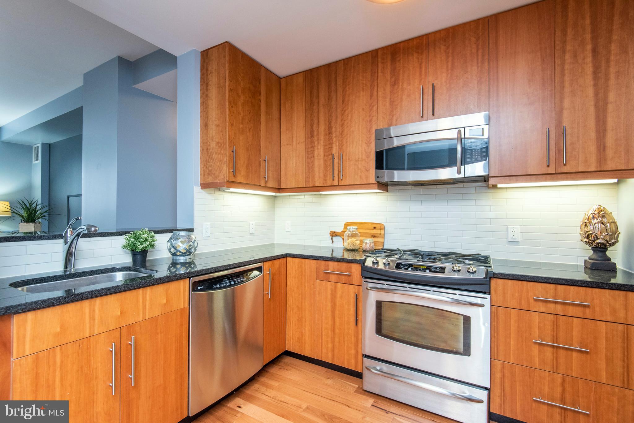 1425 Locust Street, Unit 4F Philadelphia, PA 19102 - Photo 9 of 34 a kitchen with stainless steel appliances granite countertop wooden cabinets a stove and a sink