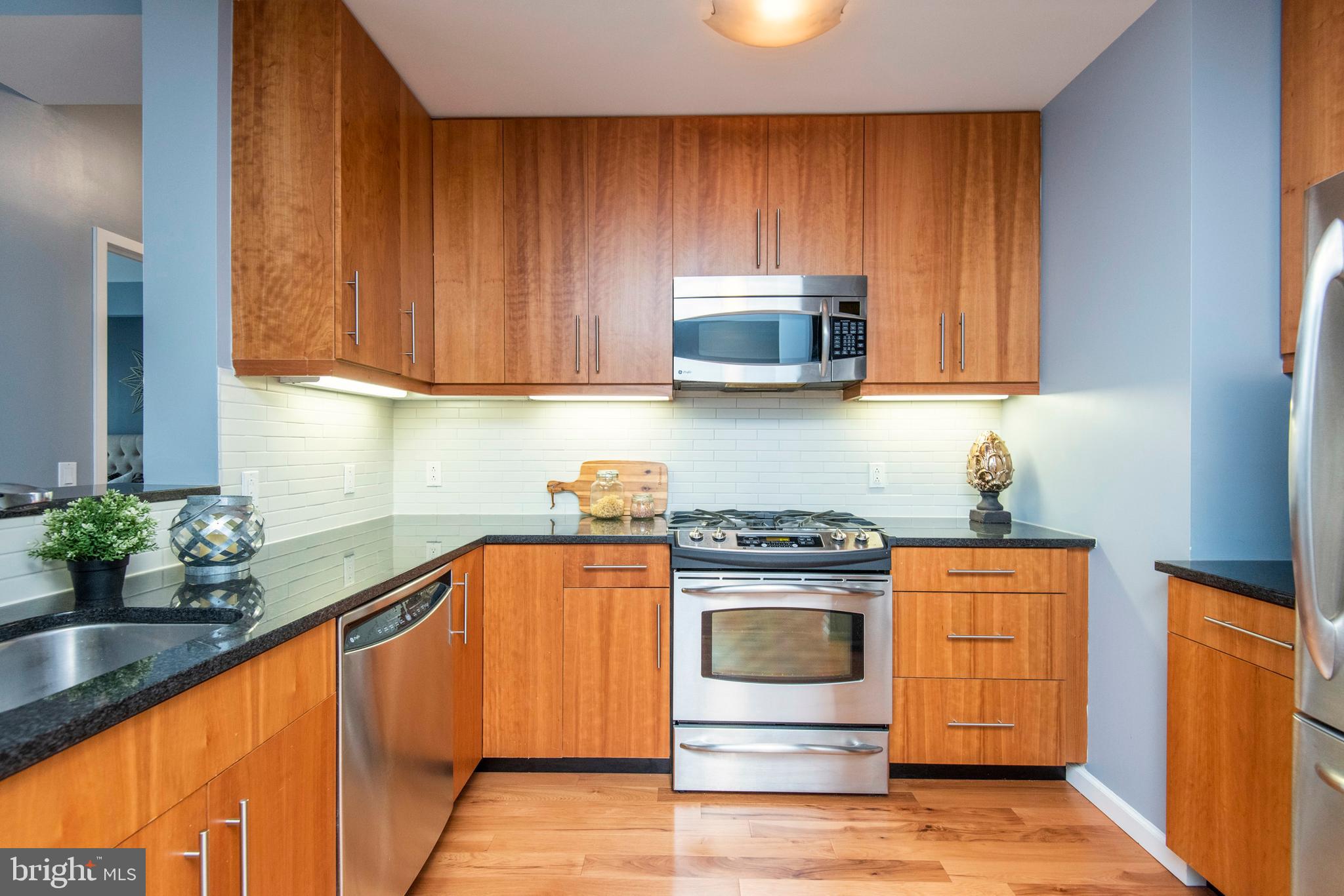 1425 Locust Street, Unit 4F Philadelphia, PA 19102 - Photo 10 of 34 a kitchen with stainless steel appliances granite countertop wooden cabinets a stove a sink and dishwasher
