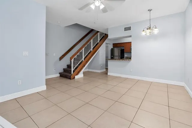 a view interior of a house with stairs and chandelier fan