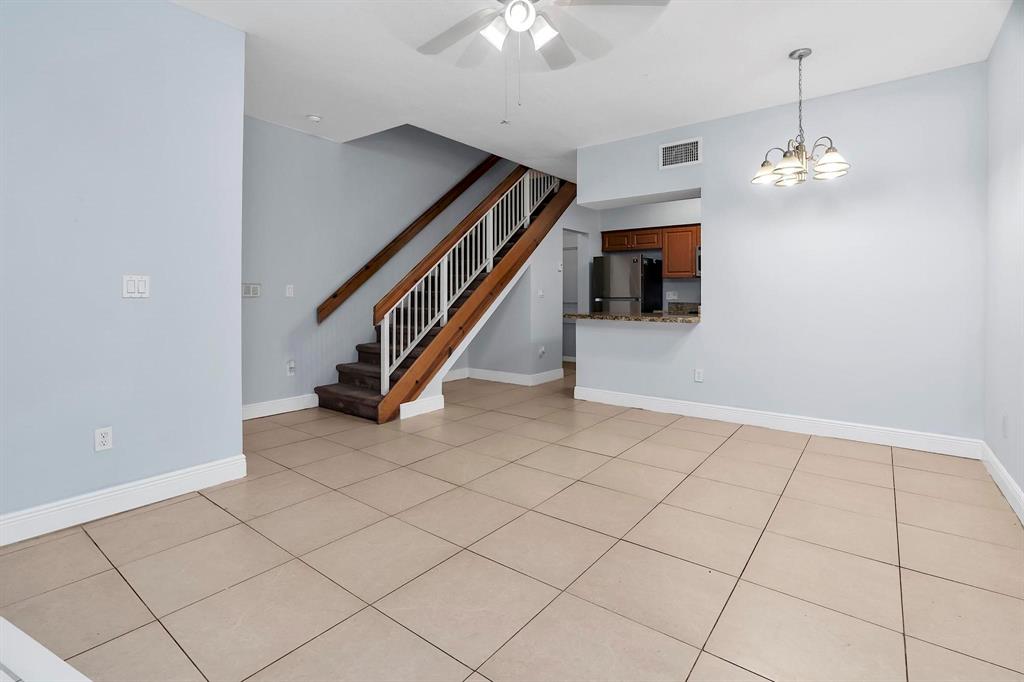 18352 Northwest 68th Avenue, Unit M Hialeah, FL 33015 - Photo 12 of 28 a view interior of a house with stairs and chandelier fan