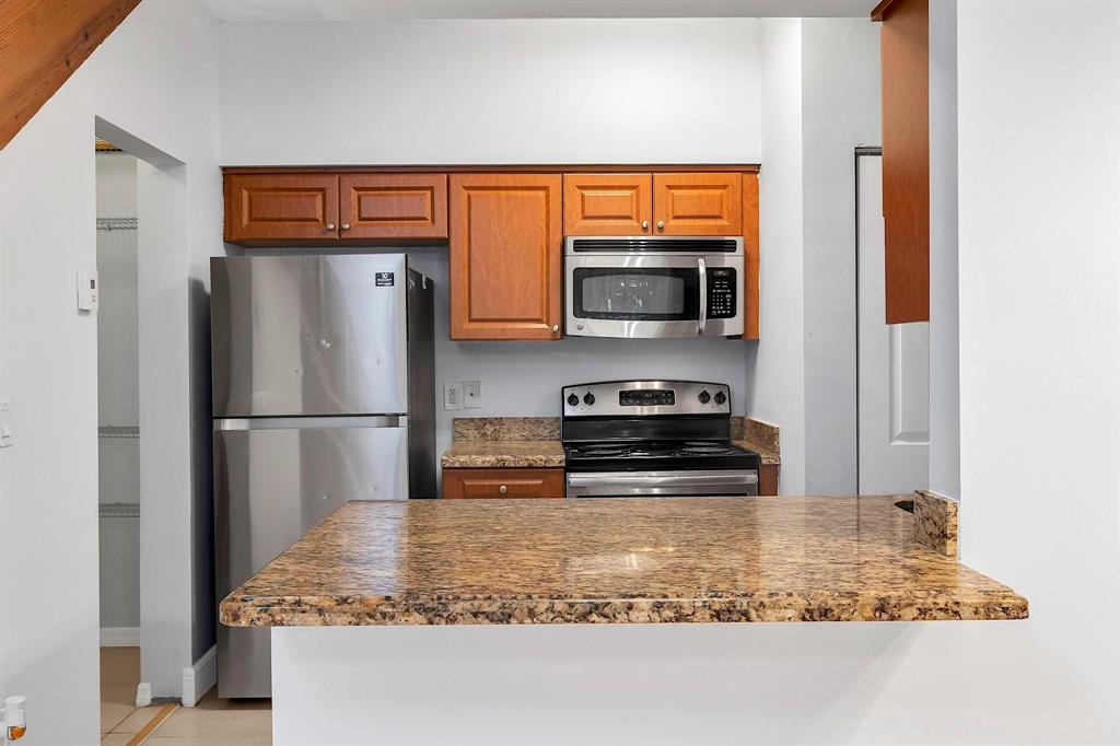 18352 Northwest 68th Avenue, Unit M Hialeah, FL 33015 - Photo 14 of 28 a kitchen with stainless steel appliances granite countertop a refrigerator a stove a microwave and a sink