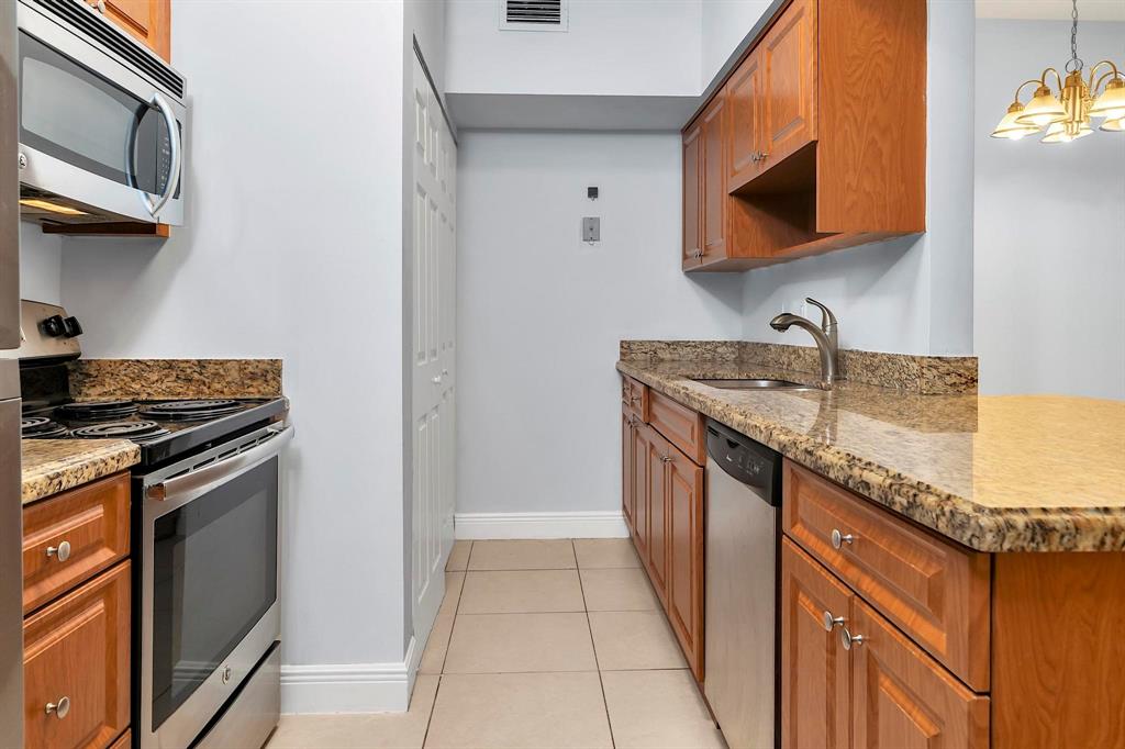18352 Northwest 68th Avenue, Unit M Hialeah, FL 33015 - Photo 16 of 28 a kitchen with stainless steel appliances granite countertop a sink stove and microwave