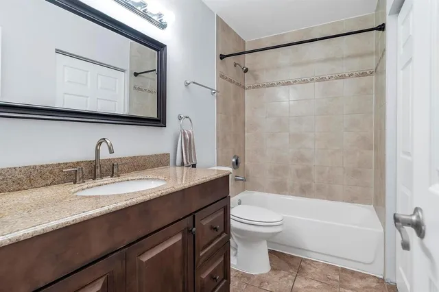a bathroom with a granite countertop sink toilet mirror and shower