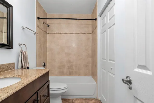 a bathroom with a granite countertop sink toilet and shower